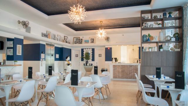 A dining area with white chairs and glass tables