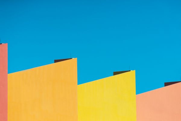 Colorful, geometric building facades against a clear, blue sky.