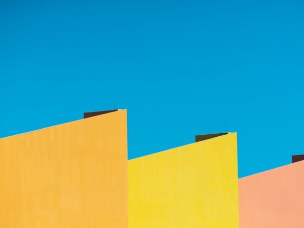 Colorful, geometric building facades against a clear, blue sky.