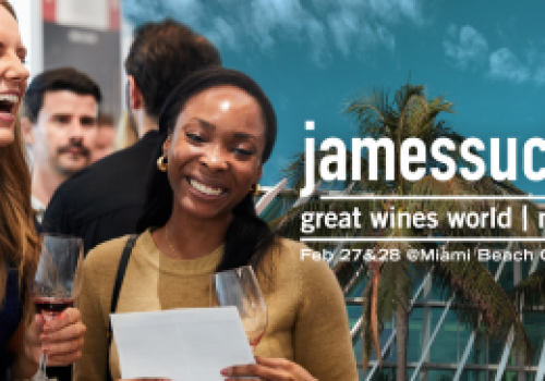 Two people enjoying wine at a promotional event for "jamessuckling great wines world" in Miami, 2025, at the Miami Beach Convention Center.